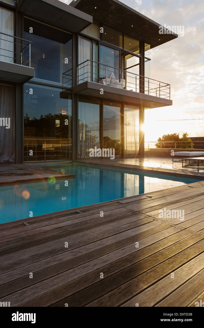 Sun behind luxury house with swimming pool Stock Photo