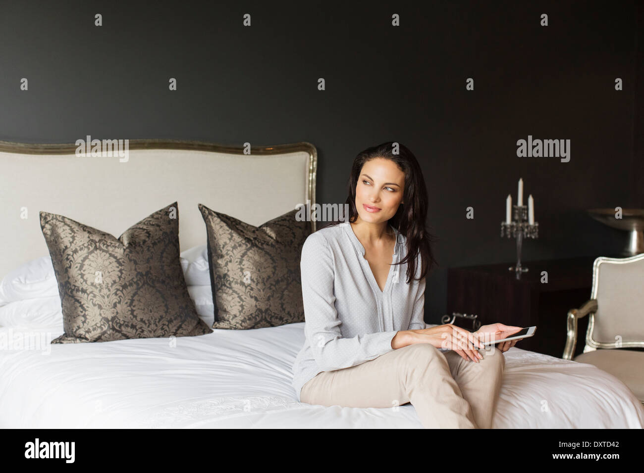 Happy woman using digital tablet in bedroom Stock Photo