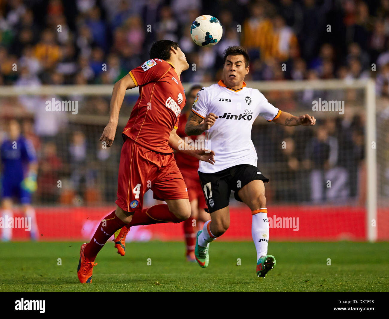 Valencia, Spain. 30th Mar, 2014. Defender Lisandro of Getafe CF (L) duels for the ball with Midfielder Eduardo Vargas of Valencia CF during the La Liga Game between Valencia CF and Getafe at Mestalla Stadium, Valencia Credit:  Action Plus Sports/Alamy Live News Stock Photo