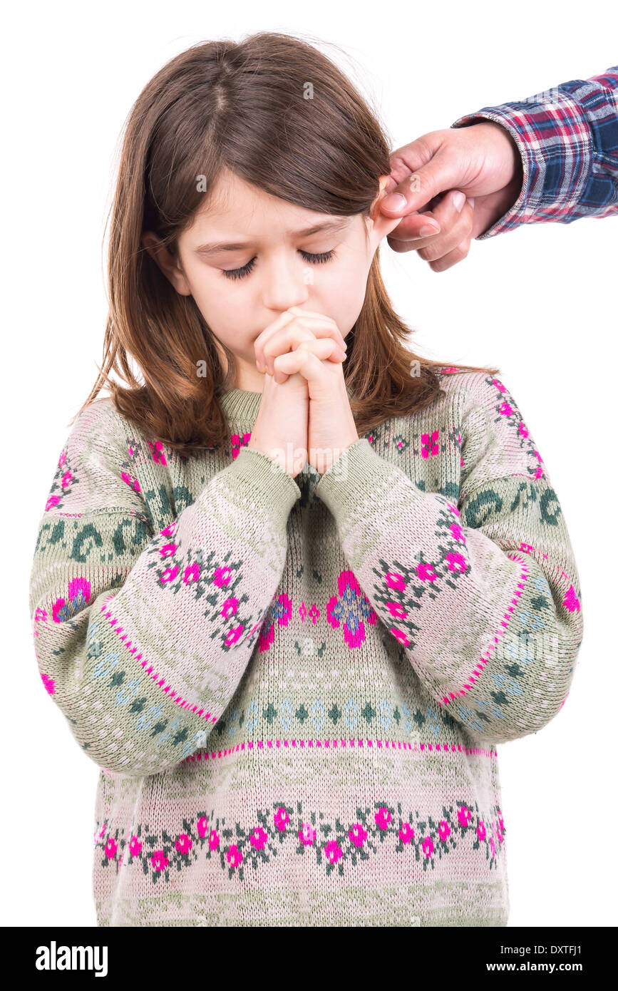 Young girl being punished with ear pulling Stock Photo
