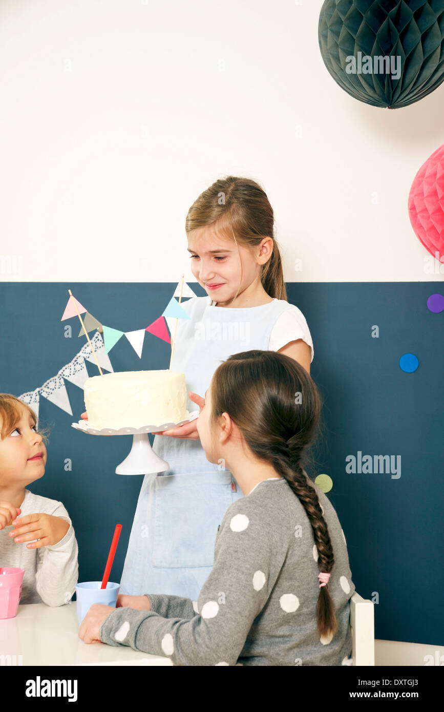 Girl on birthday party serving cake, Munich, Bavaria, Germany Stock Photo