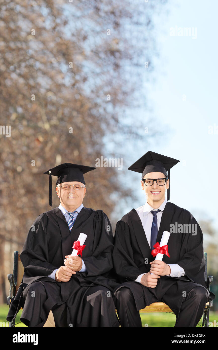 College graduate posing with a professor in park Stock Photo