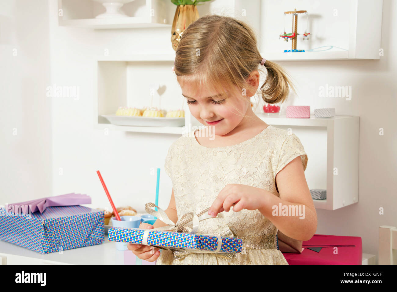 Girl on birthday unwrapping present, Munich, Bavaria, Germany Stock Photo
