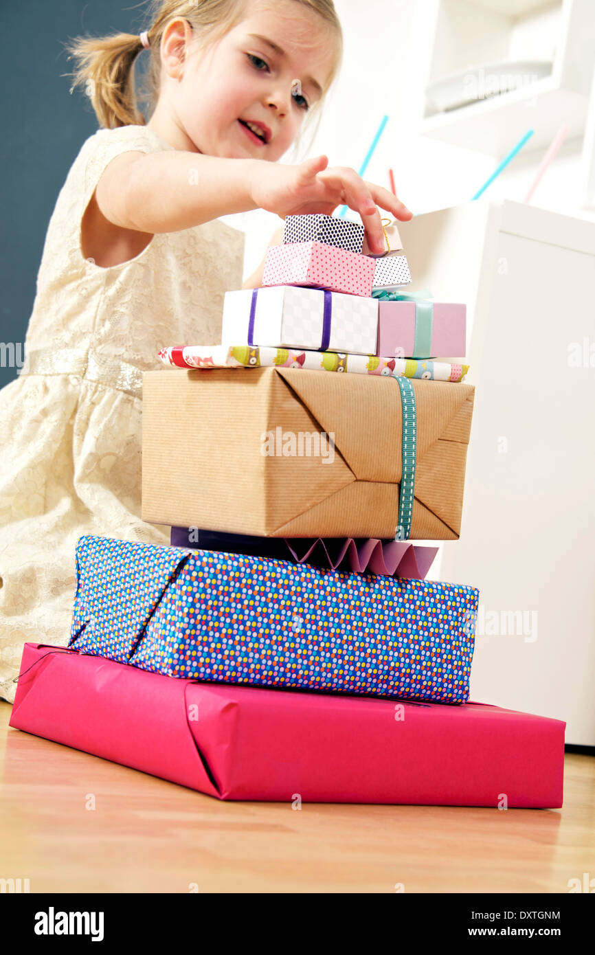 Girl on birthday looking at stack of presents, Munich, Bavaria, Germany Stock Photo