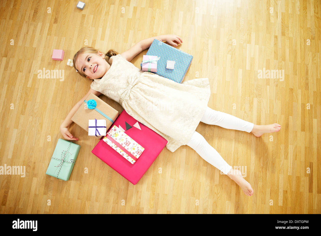 Girl lying on back among gift boxes, Munich, Bavaria, Germany Stock Photo