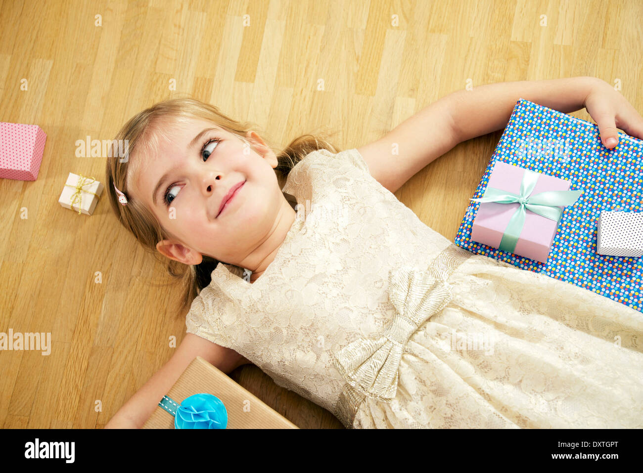 Girl lying on back among gift boxes, Munich, Bavaria, Germany Stock Photo
