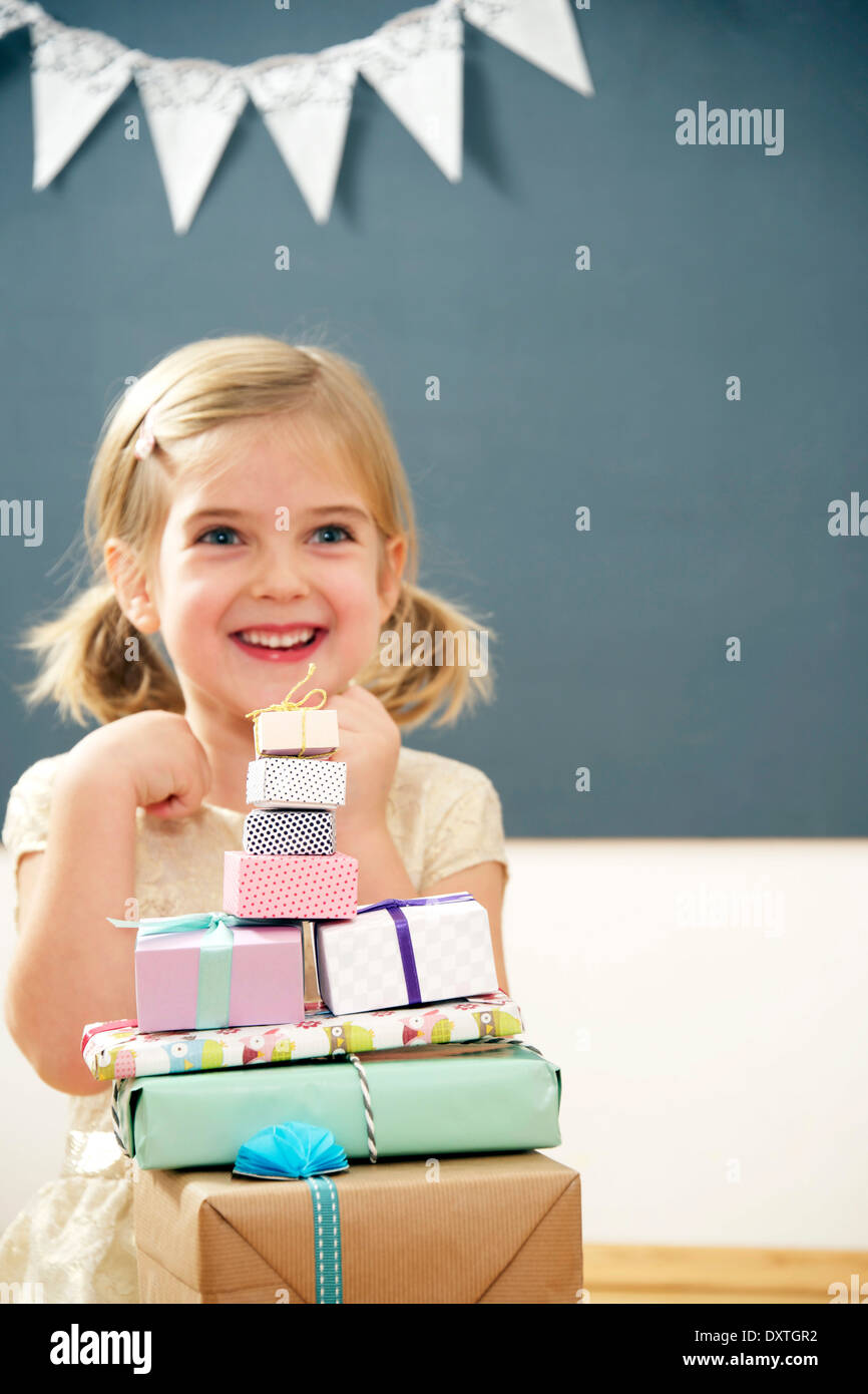 Birthday girl sitting at stack of gift boxes, Munich, Bavaria, Germany