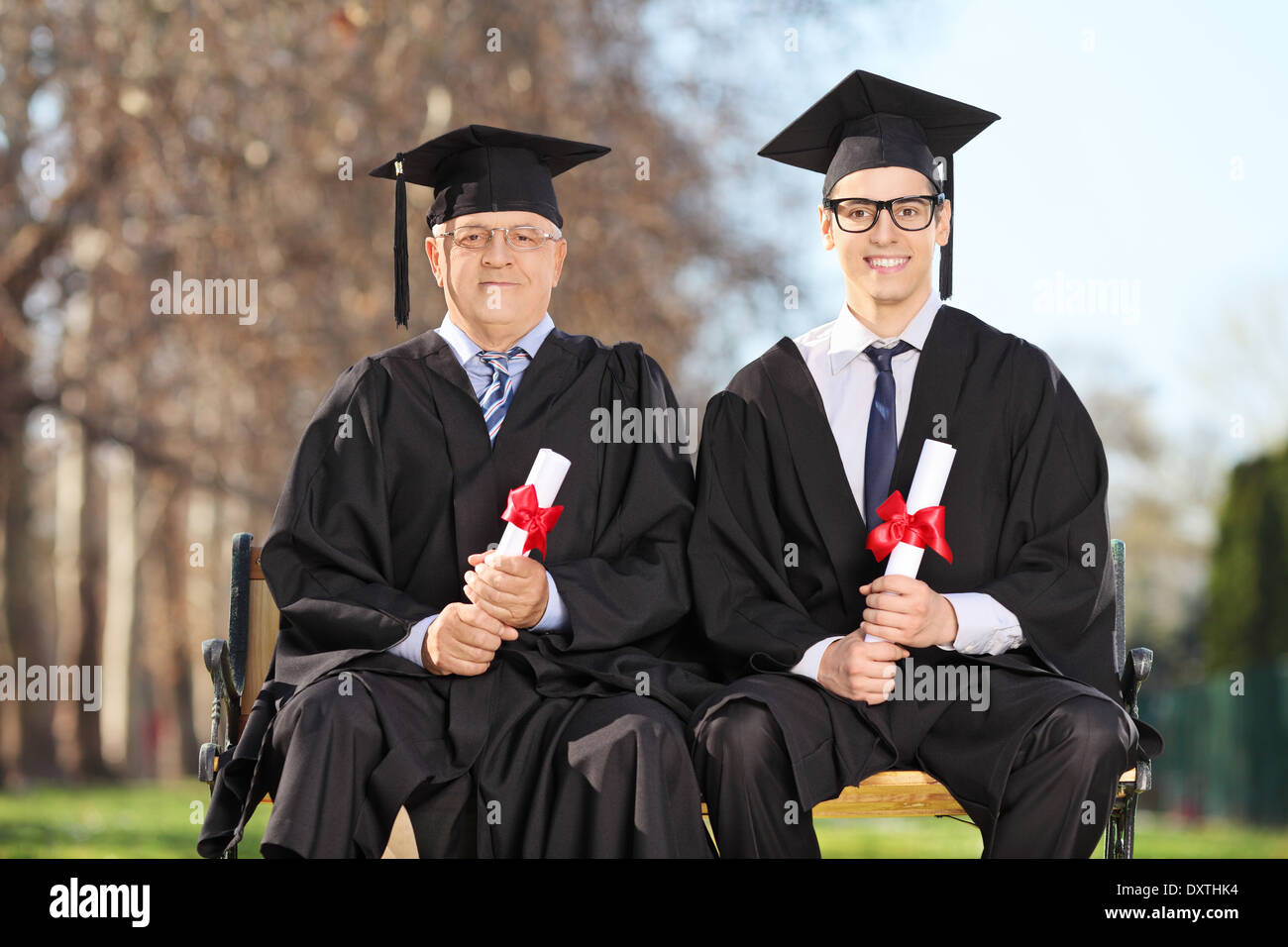 Professor and student posing on a bench in park Stock Photo