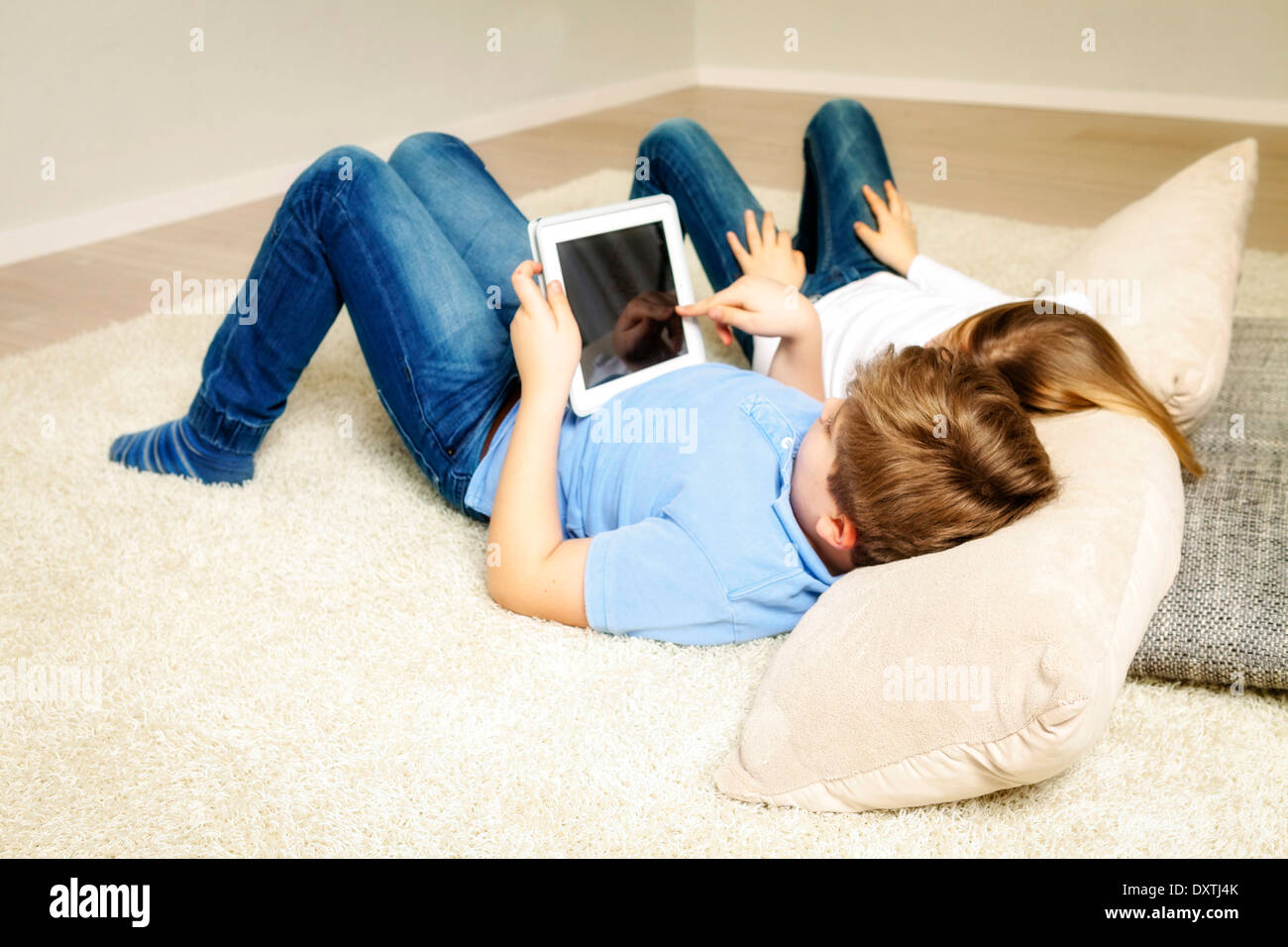 Children using tablet computer at home, having fun, Munich, Bavaria, Germany Stock Photo