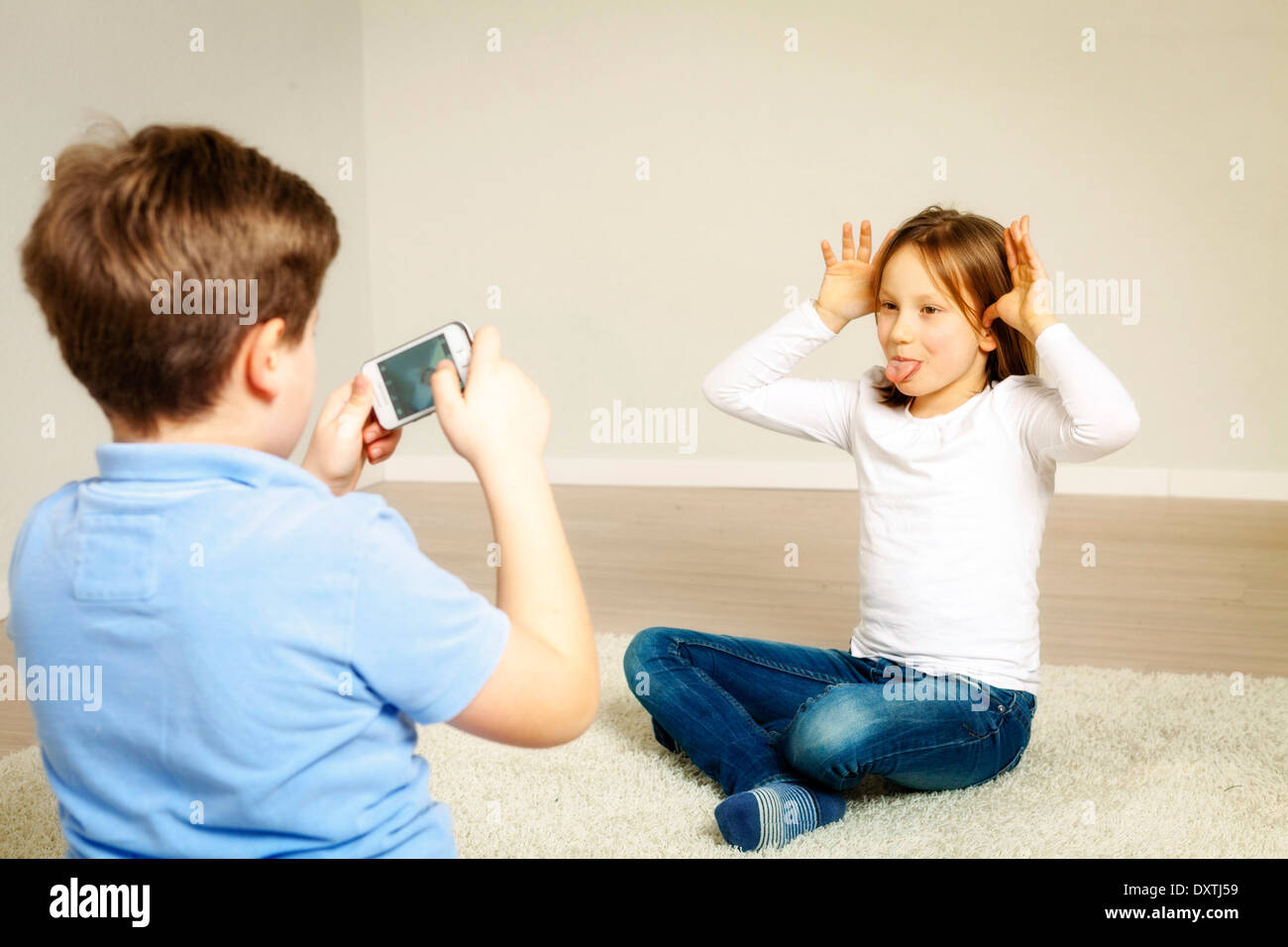 Girl making a face, boy taking picture, Munich, Bavaria, Germany Stock Photo