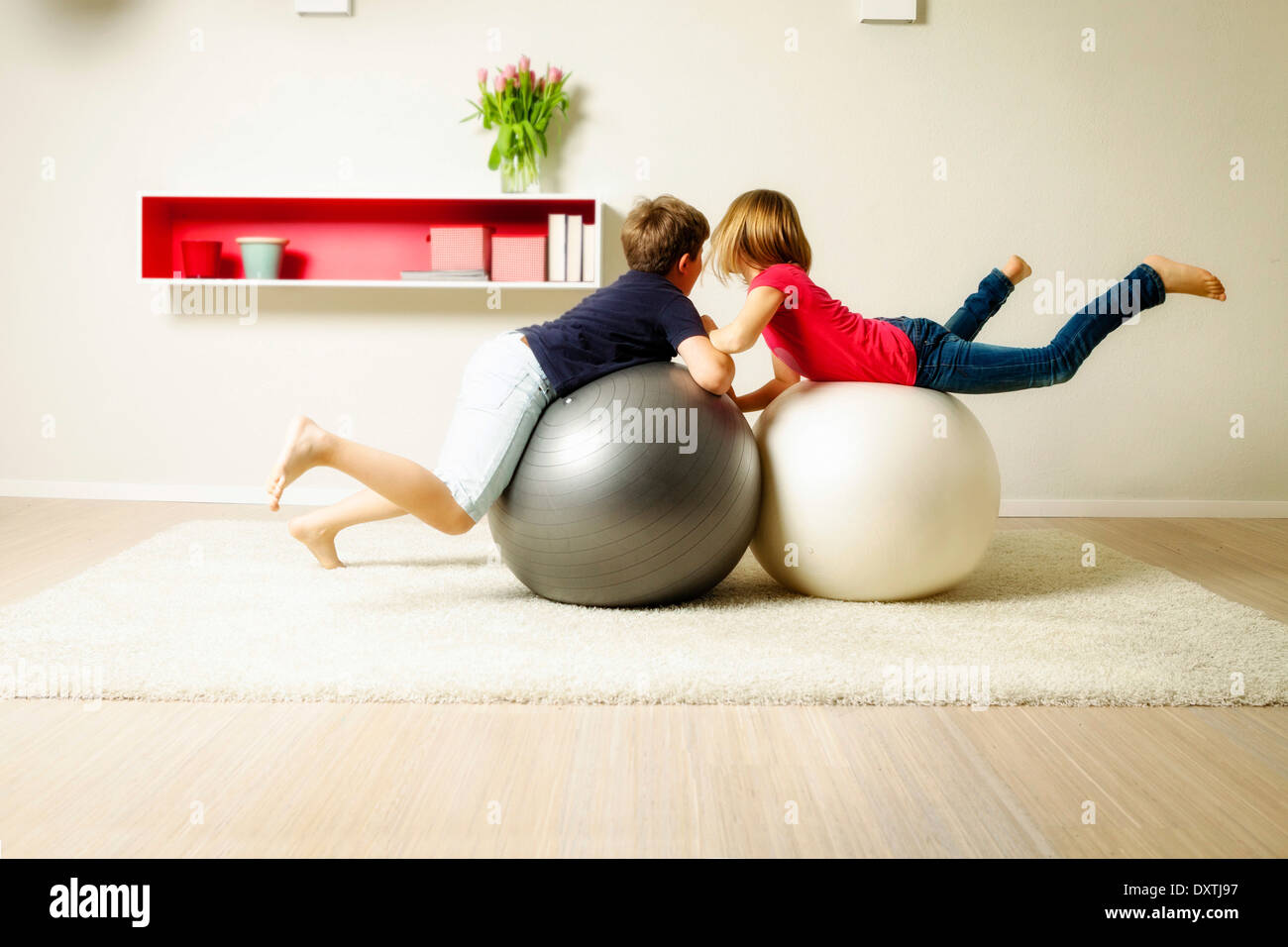 Children in living room playing with bouncing balls, Munich, Bavaria, Germany Stock Photo