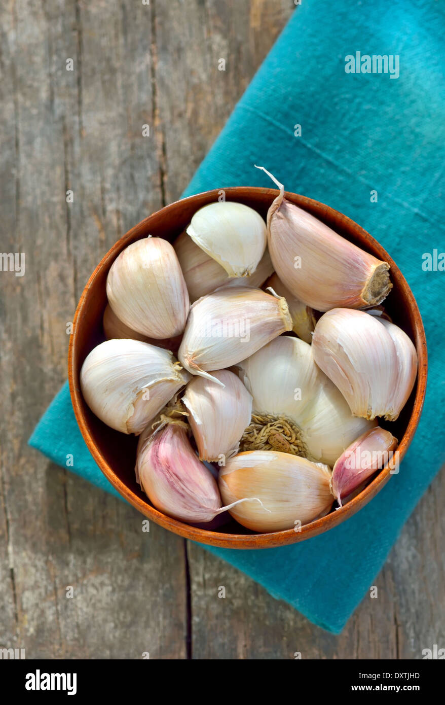 garlic in a wooden bowl on old table Stock Photo - Alamy