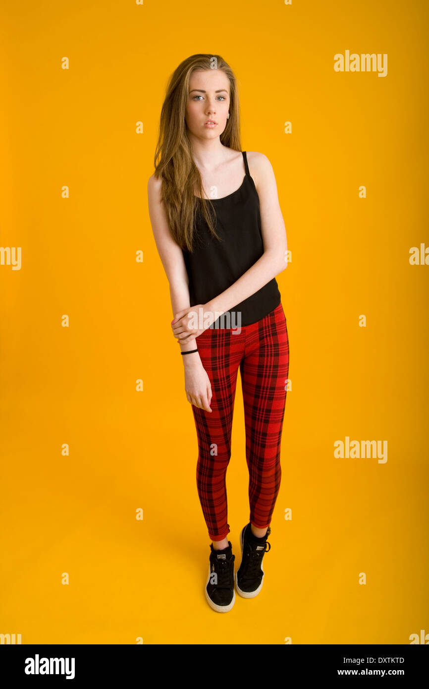 Portrait of a teenage girl standing wearing tartan leggings. Stock Photo