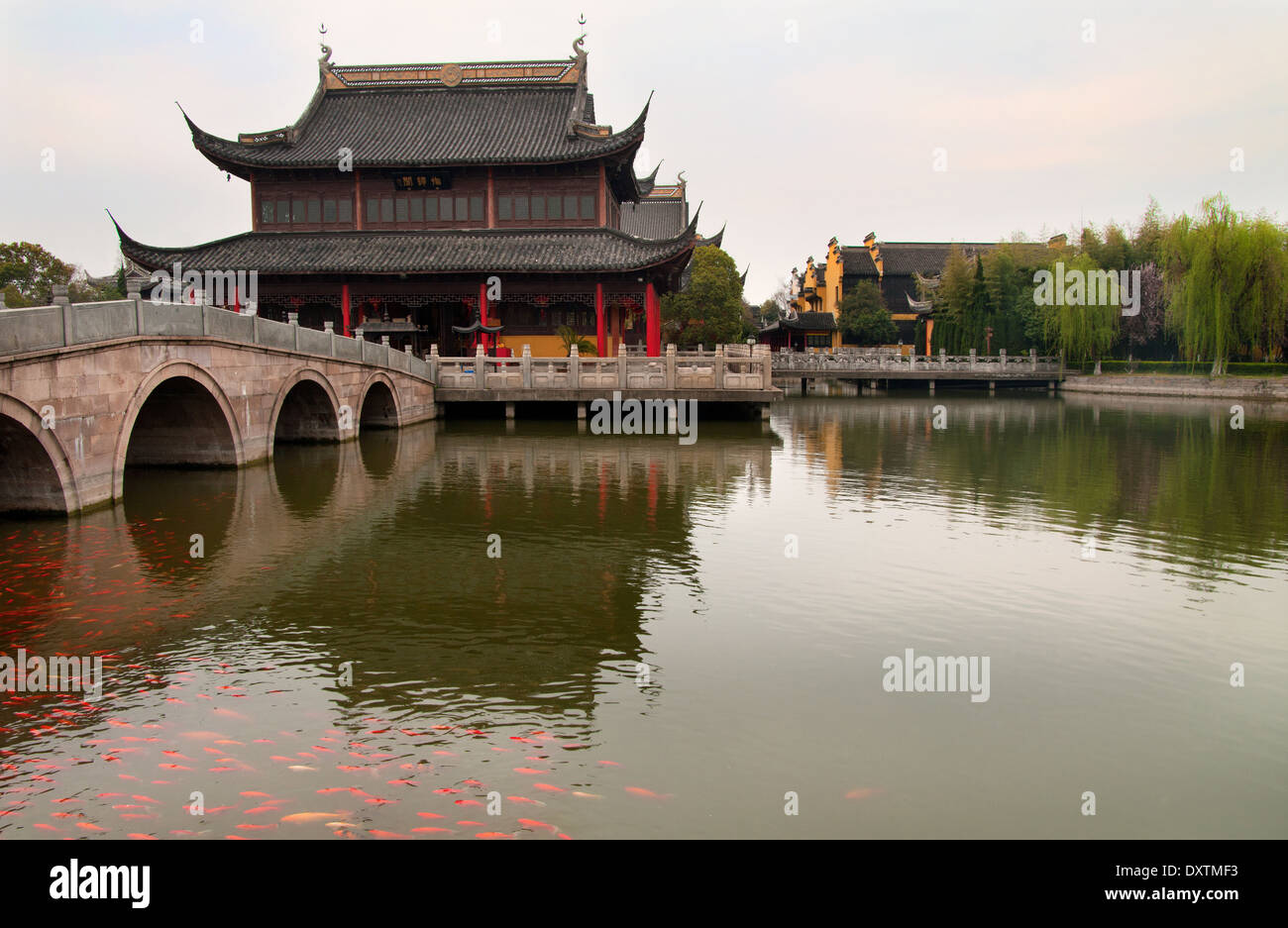 The view across the channel of the pagoda and bridge in old Chinese village. Stock Photo