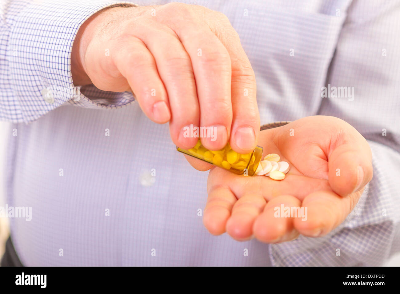 Senior adult man holds medicine capsule in his hand Stock Photo
