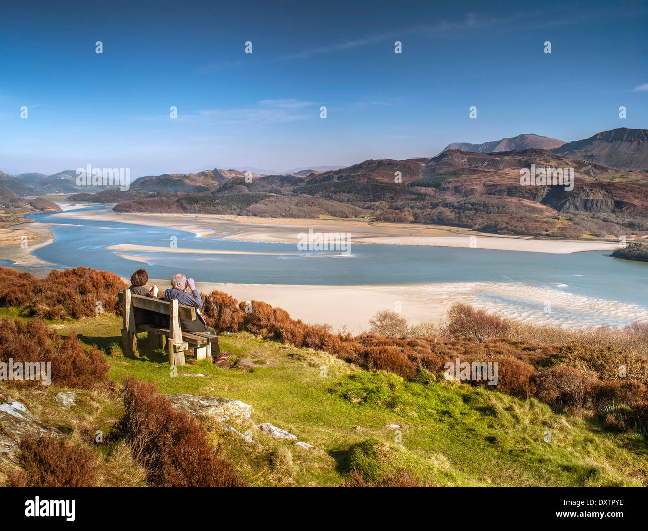 A retired couple seated on a bench at a viewpoint on Panorama Walk overlooking the Mawddach estuary and Cadair Idris range. Stock Photo