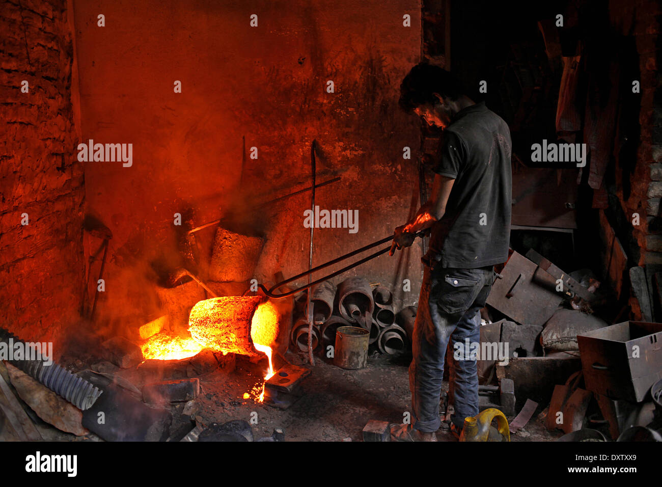 DHAKA, BANGLADESH, MARCH 2014. A worker working in a Metal factory without proper safety gear or tools.  Bangladeshi workers work in a limited workplace in often cramped conditions and without much in the way of safety equipment. Even those working in a Metal factory do so without masks or gloves exposing them to the risk of accidents or diseases. (Photo by Sumon Yusuf / Pacific Press) Stock Photo
