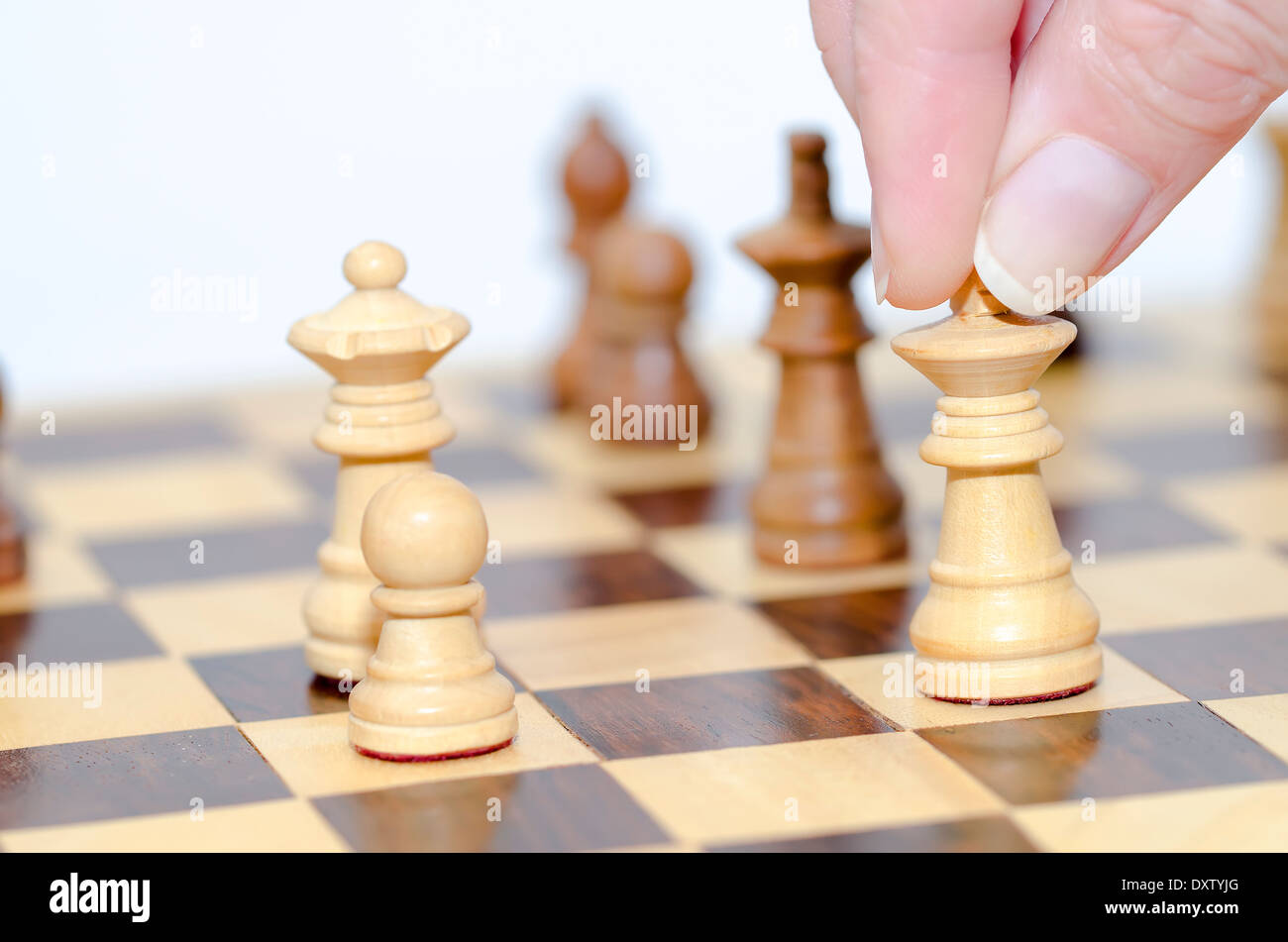 A skilled hand deftly slides a chess piece marked Chess across