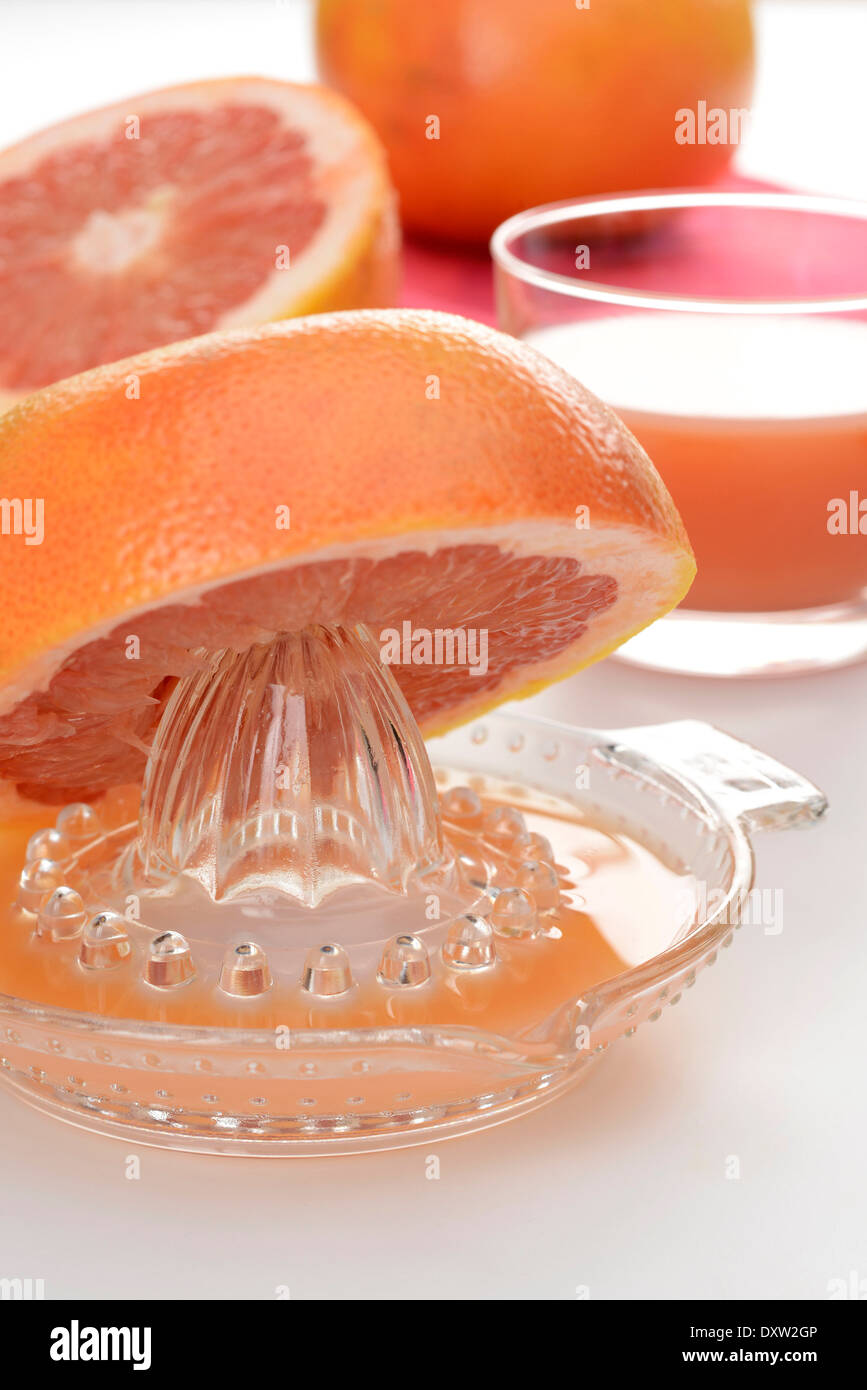 Squeezing pink grapefruit juice Stock Photo