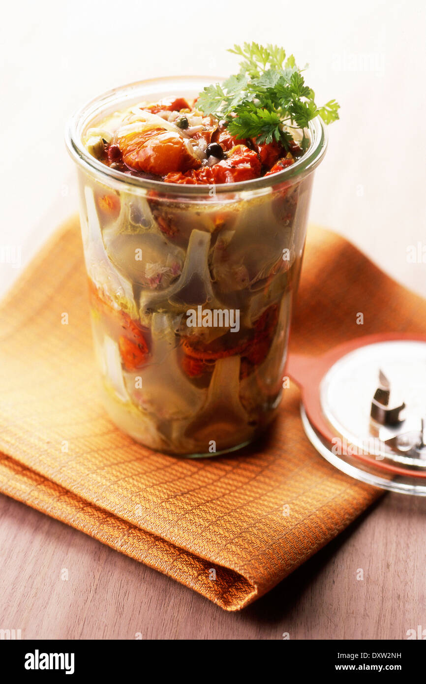 Jar of artichokes with sun-dried cherry tomatoes Stock Photo