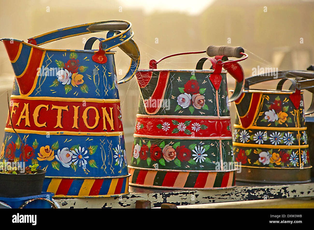 Colourful decorated pots and jugs stand on the roof of a canal narrowboat in Bancroft Marina, Stratford upon Avon canal. Stock Photo