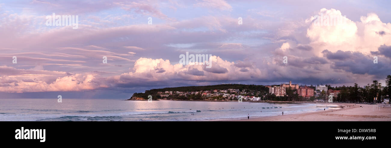 panorama of Manly Beach Sydney with dramatic lavender sunset sky, calm reflective ocean and golden sand Stock Photo