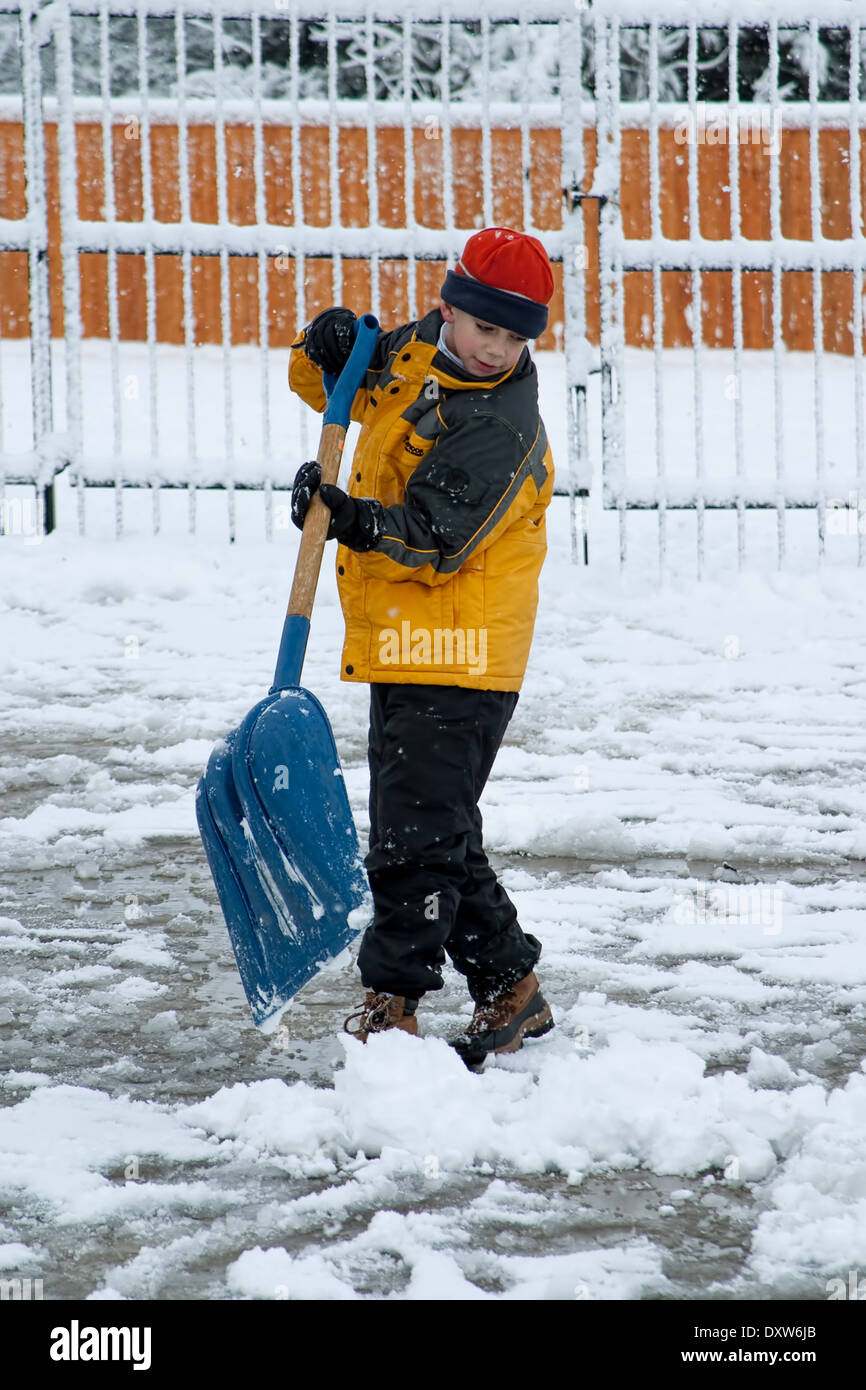 Young Boy Shoveling Snow off Driveway Stock Photo