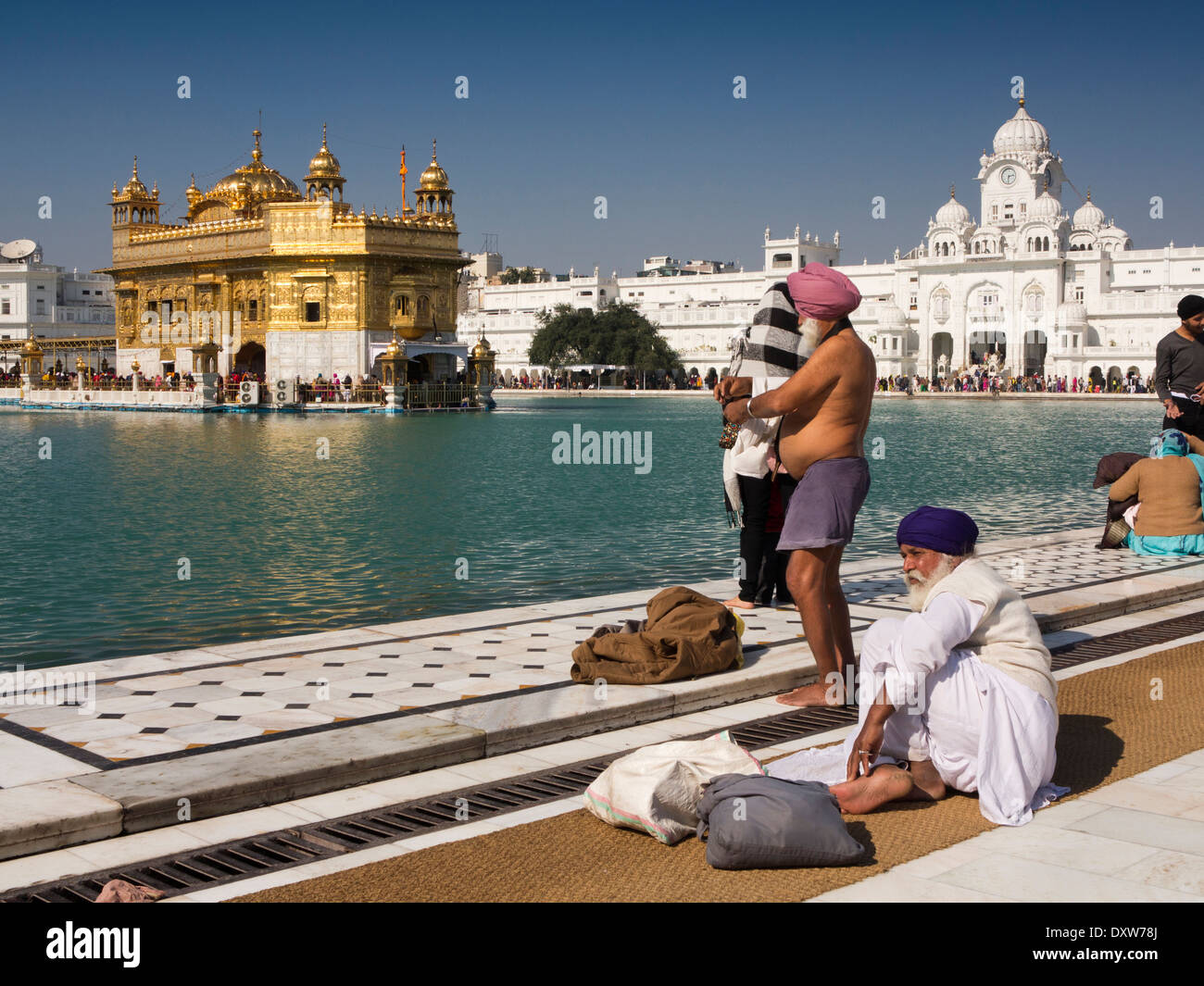 India, Punjab, Amritsar, Sri Harmandir or Darbar Sahib, Golden Temple Sikh men at edge of Sarovar holy tank Stock Photo