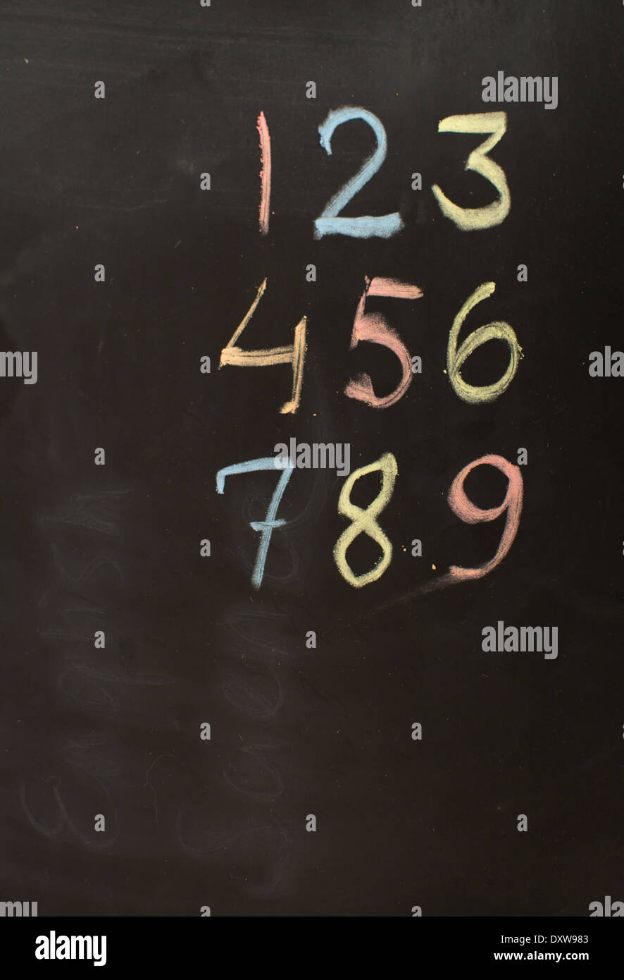 Numbers 1-9 in colored chalk on blackboard. Stock Photo