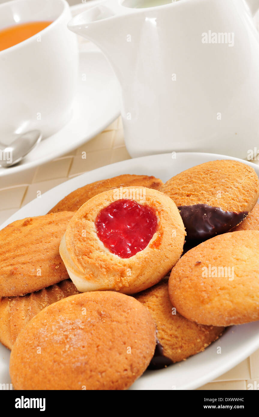 a cup with tea and some biscuits in a plate, on a set table Stock Photo