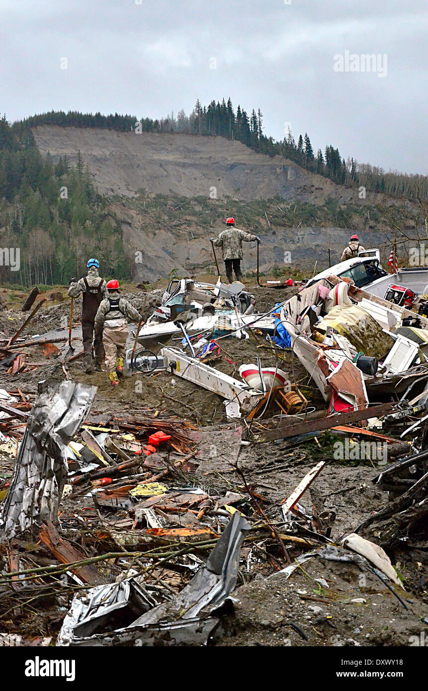 Rescue workers continue efforts to locate victims of a massive landslide that killed at least 28 people and destroyed a small riverside village in northwestern Washington state March 29, 2014 in Oso, Washington. Stock Photo