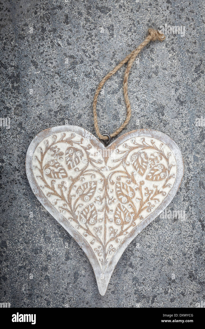 A carved wooden heart on a grey limestone background Stock Photo