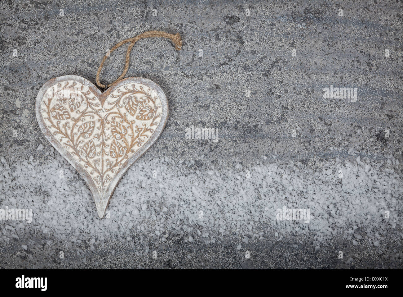 A carved wooden heart on a grey limestone background Stock Photo