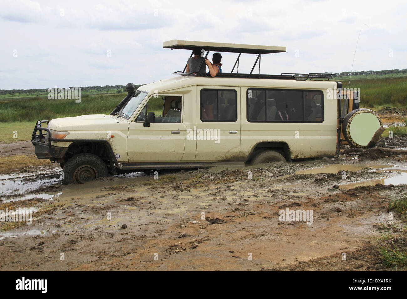 Safari vehicle with tourists, stuck in the mud, Serengeti, Tanzania Stock Photo