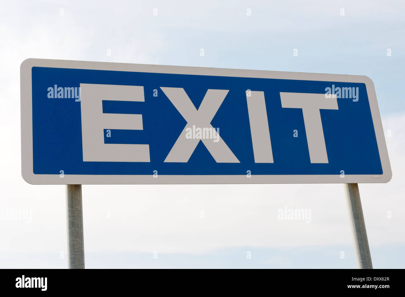 A large blue and white Exit sign against a clear blue sky. Stock Photo