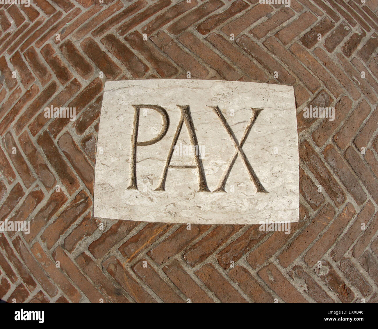 inscription PAX as a symbol of peace on a plaque in the midst of bricks 1 Stock Photo