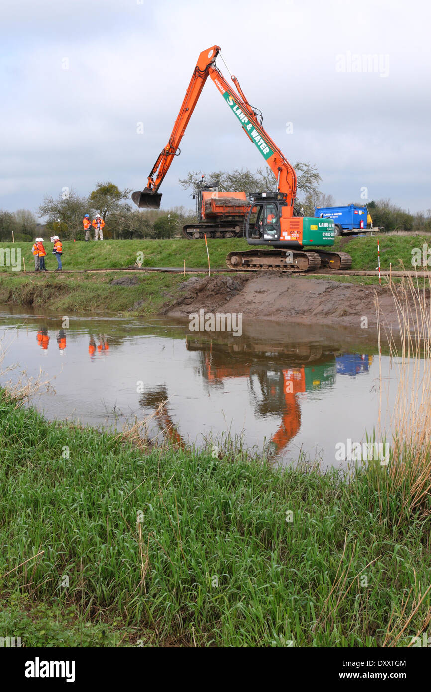 Moorland, near Burrowbridge, Somerset, UK. 1st April 2014. Environment Agency workers watch Day 2 of the dredging operation along the banks of the River Parrett on the Somerset Levels. Todays dredging was hampered by the use of only one dumper truck to remove the dredged silt which meant a lot of productive time was lost. Stock Photo