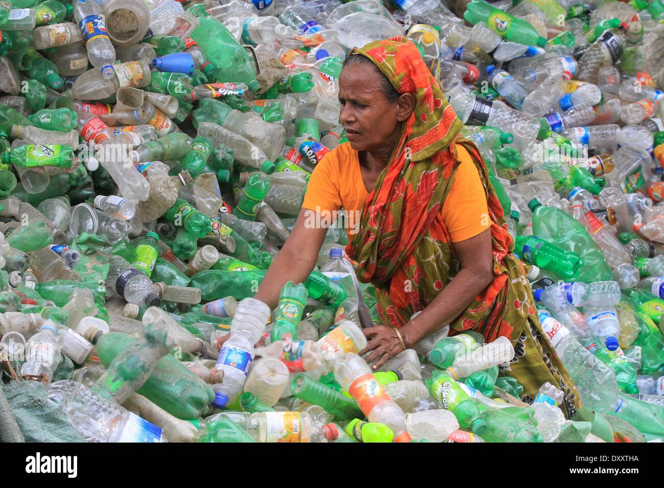 Bangladeshi people works in a plastic bottle recycling factory besides