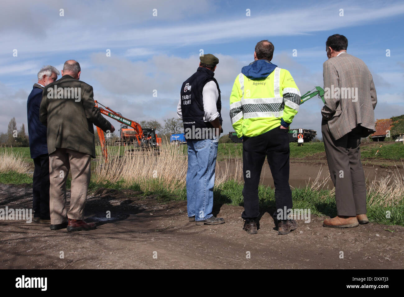 Moorland, near Burrowbridge, Somerset, UK. 1st April 2014. Environment Agency managers talk with local farmers and residents about Day 2 of the dredging operation along the banks of the River Parrett on the Somerset Levels. Todays dredging was hampered by the use of only one dumper truck to remove the dredged silt which meant a lot of time was wasted which did not impress the locals. Stock Photo