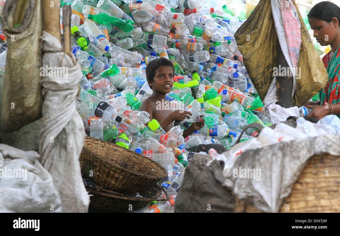 Bangladeshi people works in a plastic bottle recycling factory besides