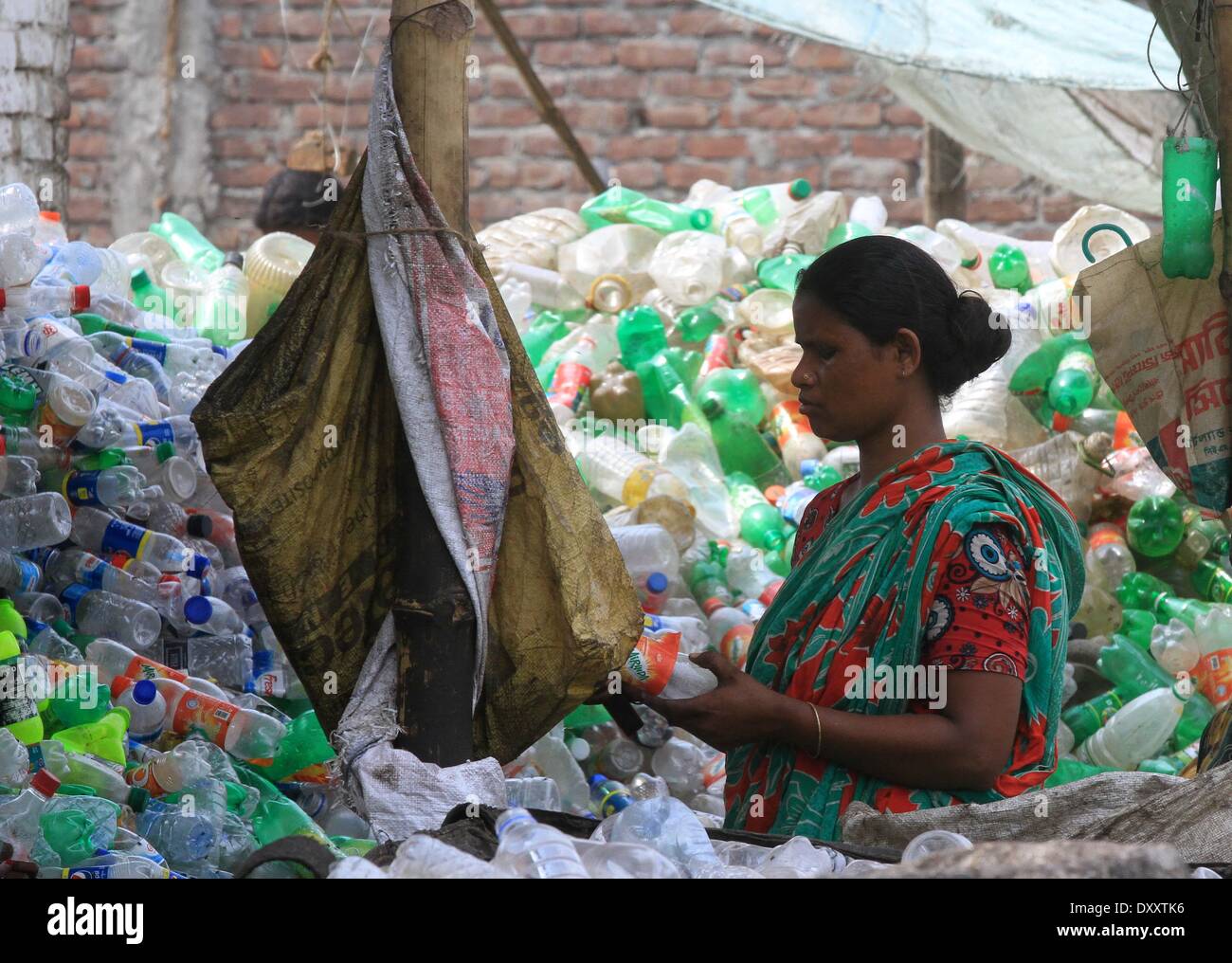 Bangladeshi people works in a plastic bottle recycling factory besides