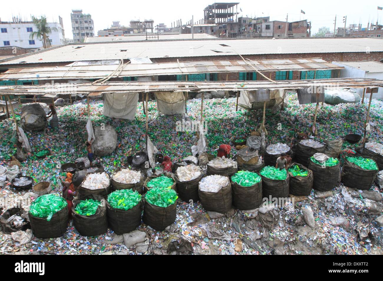Bangladeshi people works in a plastic bottle recycling factory besides