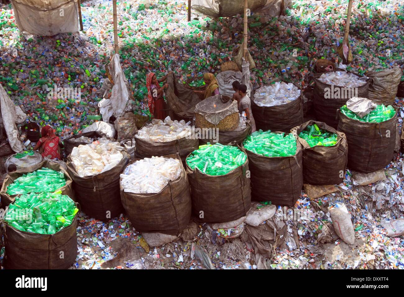 Bangladeshi people works in a plastic bottle recycling factory besides