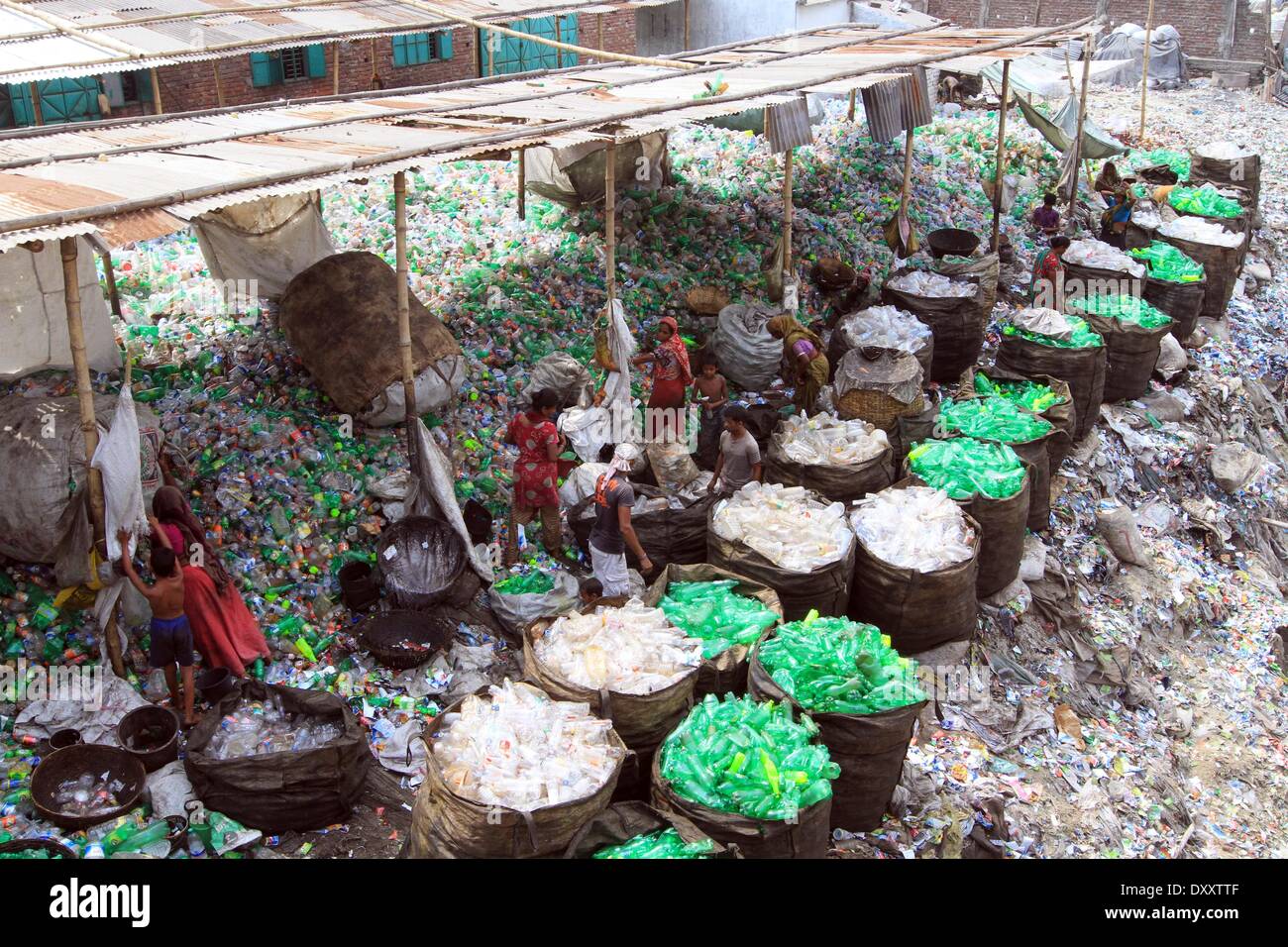 Bangladeshi people works in a plastic bottle recycling factory besides