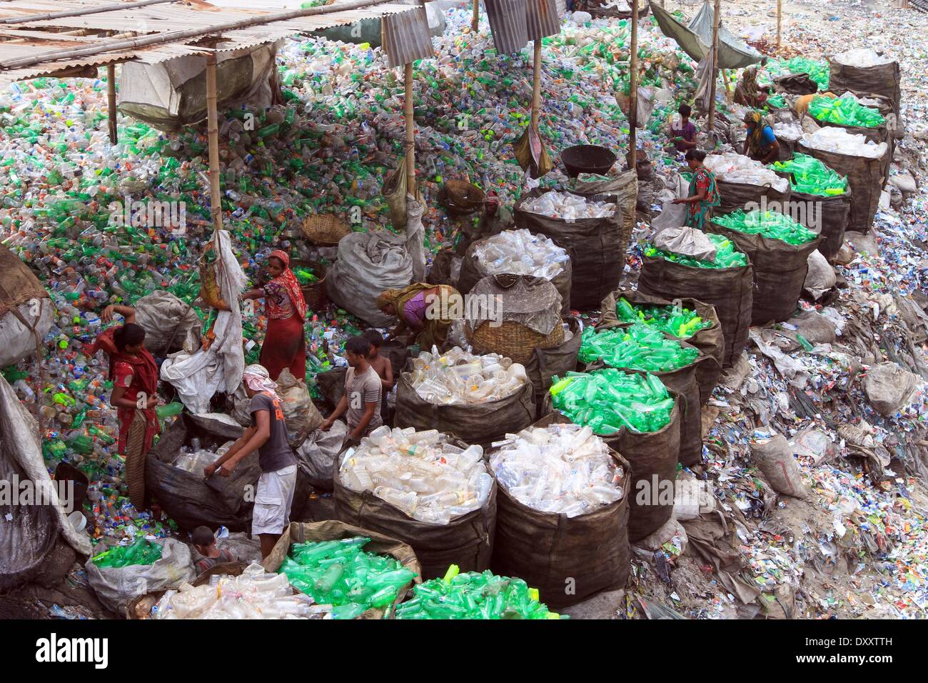Bangladeshi people works in a plastic bottle recycling factory besides