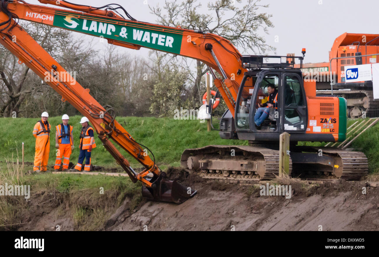 Burrowbridge, Somerset, UK. 31st March 2014. Work has commenced on the dredging of the River Parrett as part of a 20 year plan to alleviate the risk of flooding on the Somerset Levels. Contractors are shown operating long reach machinery just north of Burrowbridge to clear the banks ready for dredging to commence. Credit:  Mr Standfast/Alamy Live News Stock Photo