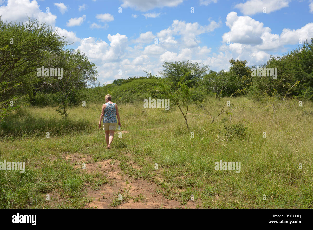 woman walking en enjoy nature with bleu sky and white clouds in africa Stock Photo