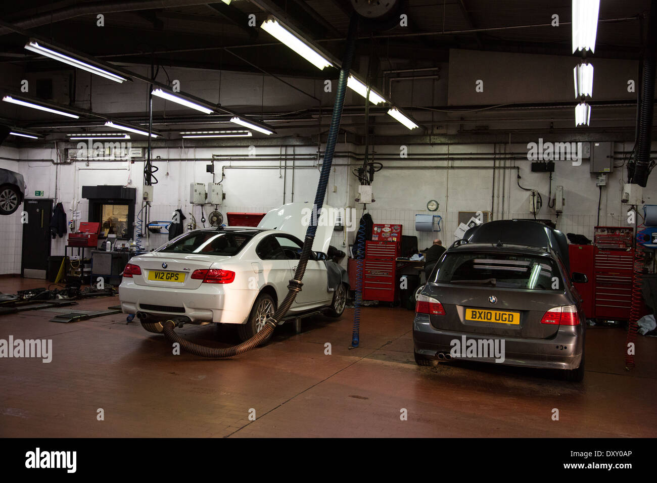 Cars in a garage service bay Stock Photo Alamy