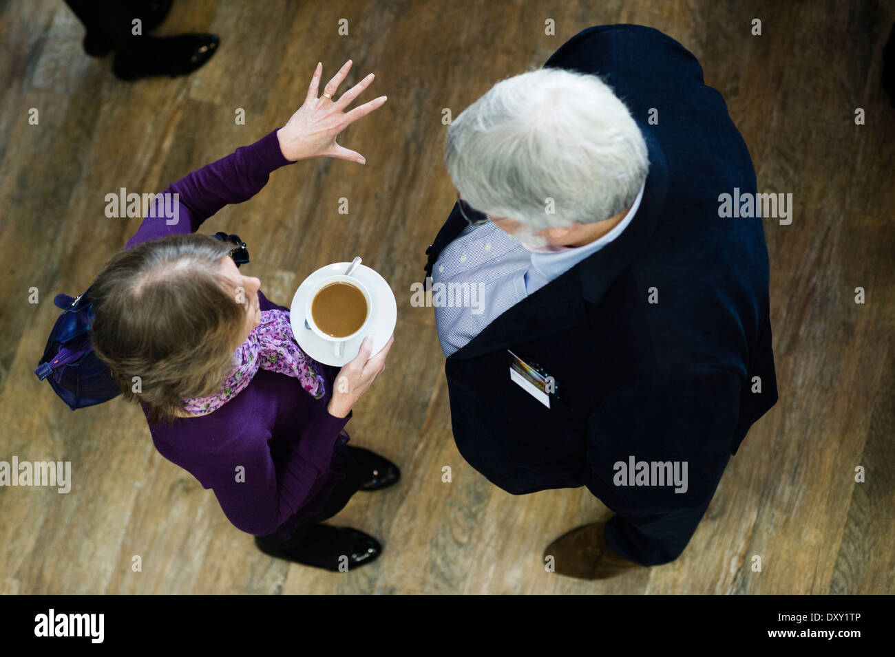 Overhead view of a businessman and woman talking together during coffee break at a business networking conference event UK Stock Photo