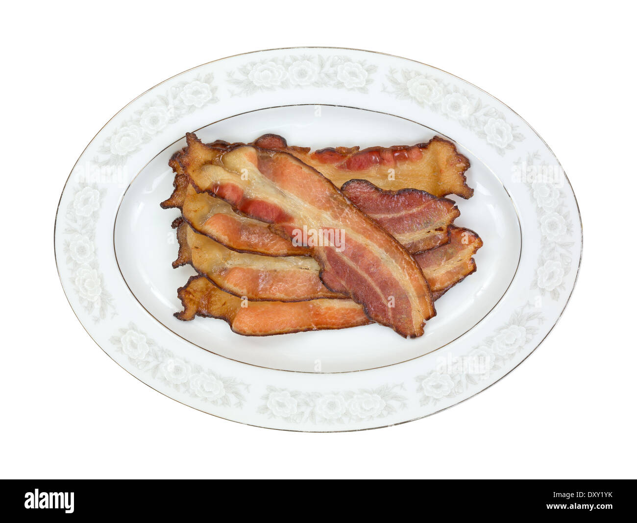 Top view of freshly cooked smoked thick sliced bacon on an old glass platter. Stock Photo